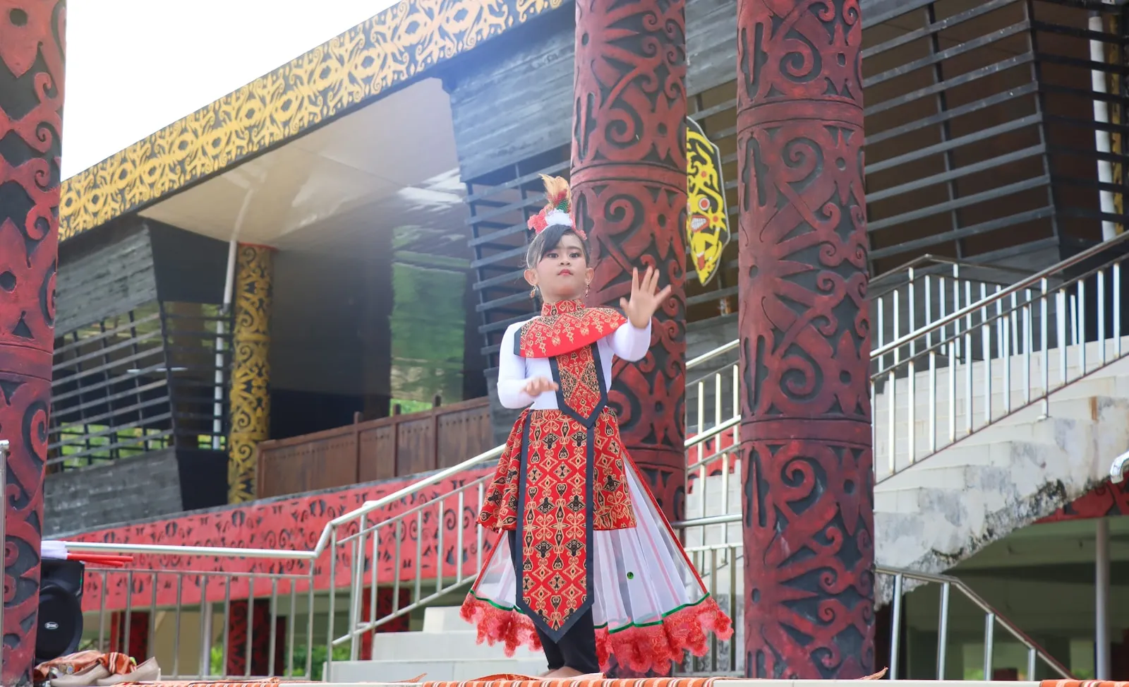 a woman in a red and white dress standing in front of a building