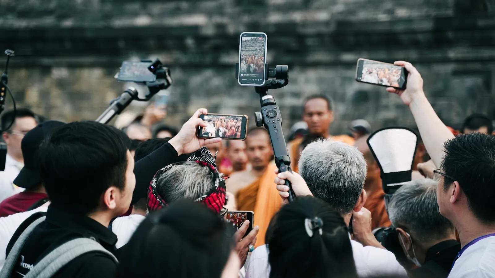 a group of people taking pictures with their cell phones