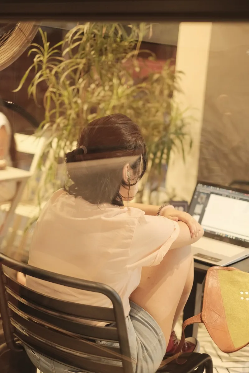 a woman sitting at a desk with a laptop computer