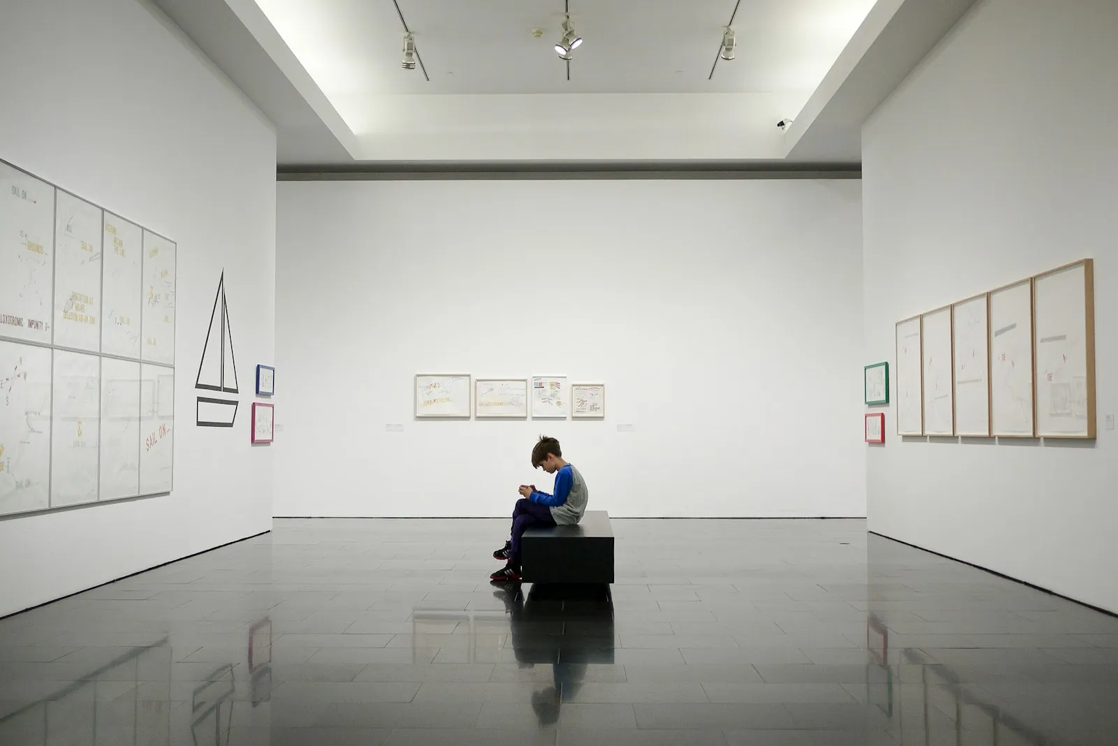 man sitting near museum painting