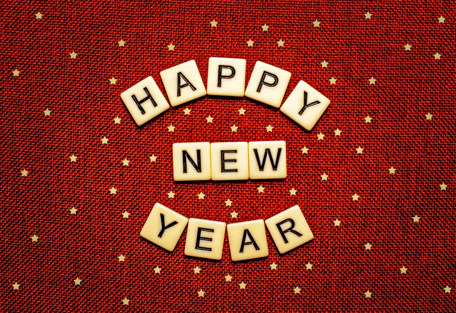 happy new year spelled with scrabbles on a red background