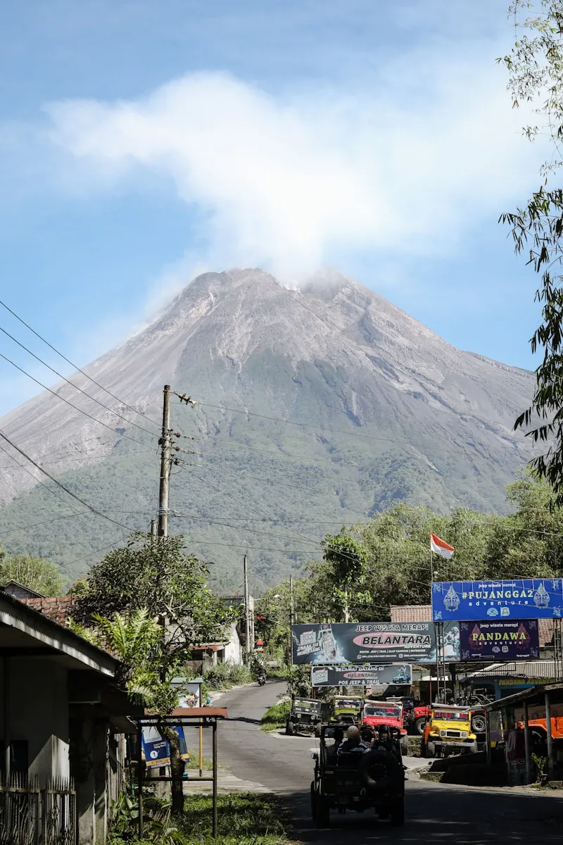 a very tall mountain towering over a small town